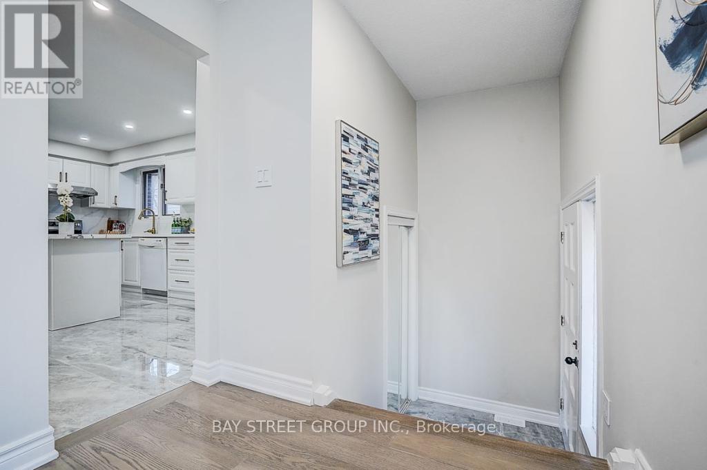 A spacious kitchen with white cabinets and a marble floor.