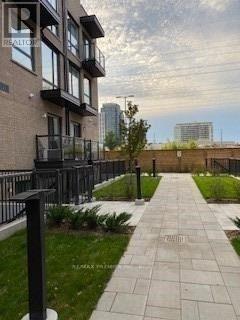 A walkway with a metal railing and a grassy area on the side.