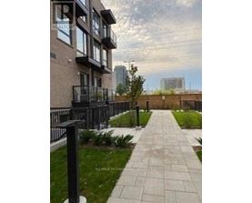 A walkway with a metal railing and a grassy area on the side.