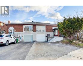 A white car is parked in front of a brick house.