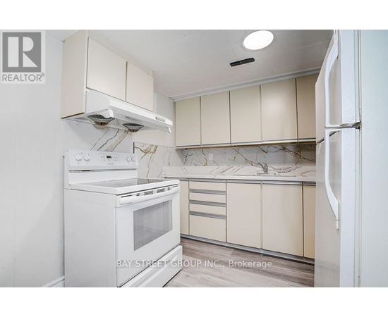 A white oven and refrigerator in a kitchen with beige cabinets.