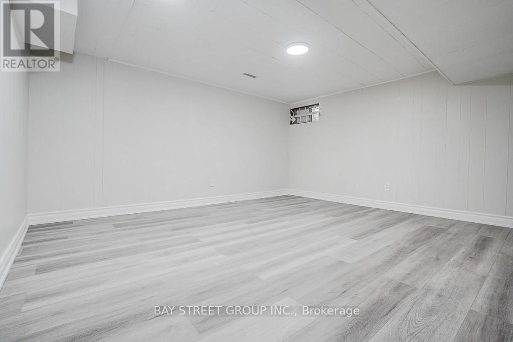 A spacious room with a wooden floor and white walls.