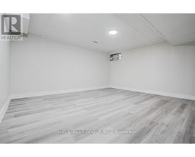 A spacious room with a wooden floor and white walls.