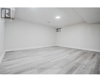 A spacious room with a wooden floor and white walls.