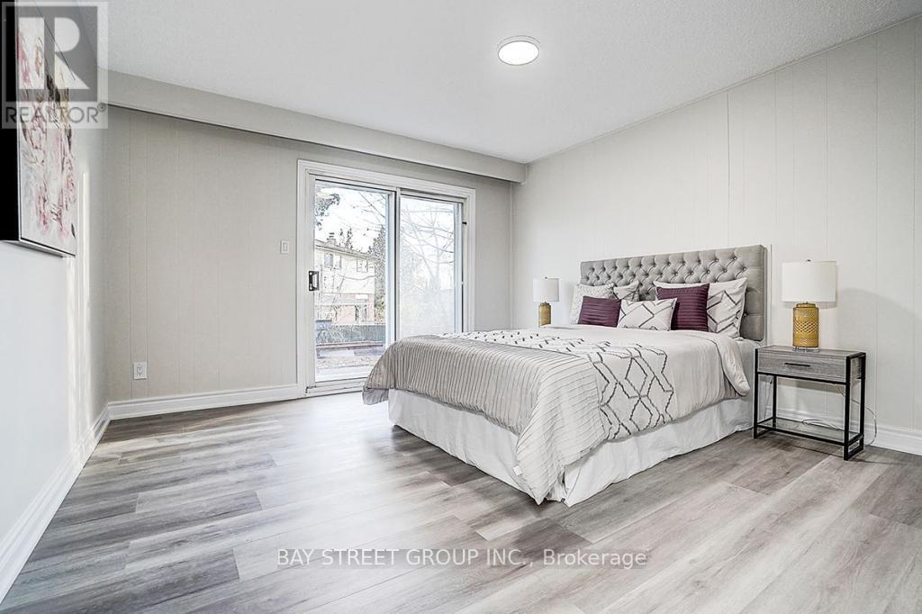 A bedroom with a large bed and a sliding glass door.