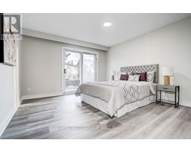 A bedroom with a large bed and a sliding glass door.