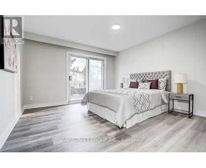 A bedroom with a large bed and a sliding glass door.