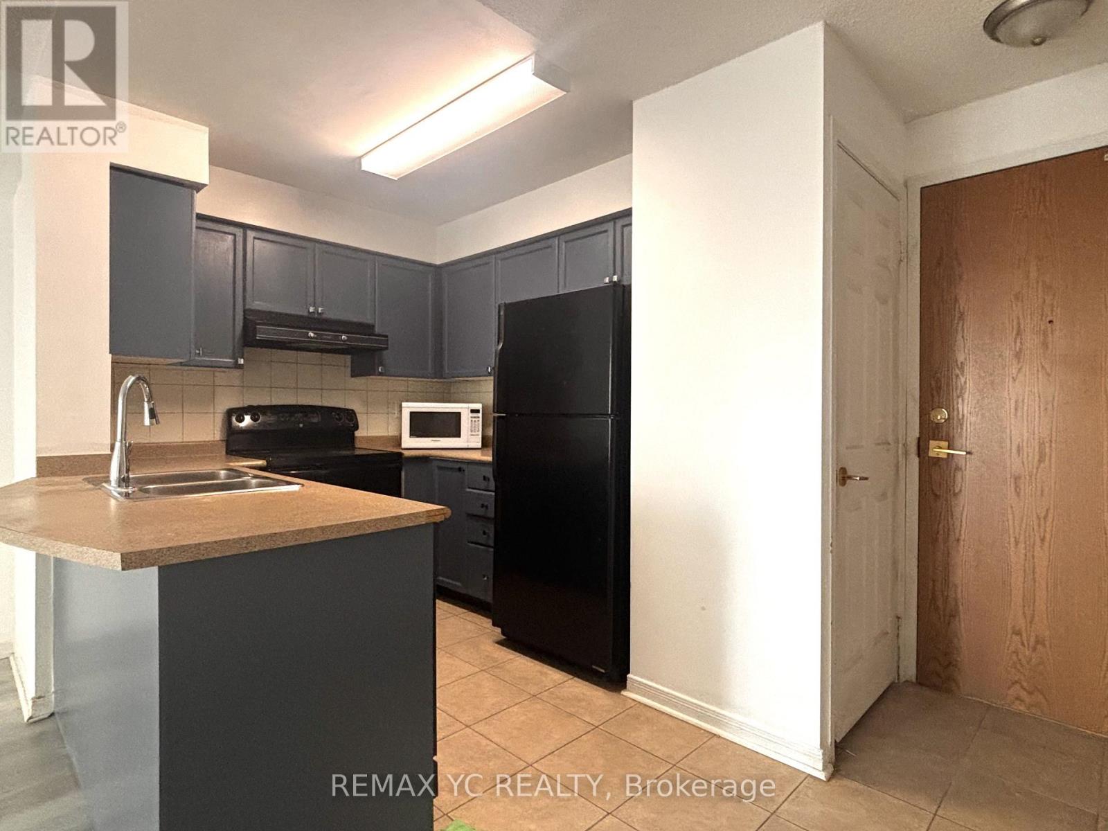 A kitchen with a sink, stove, and refrigerator.