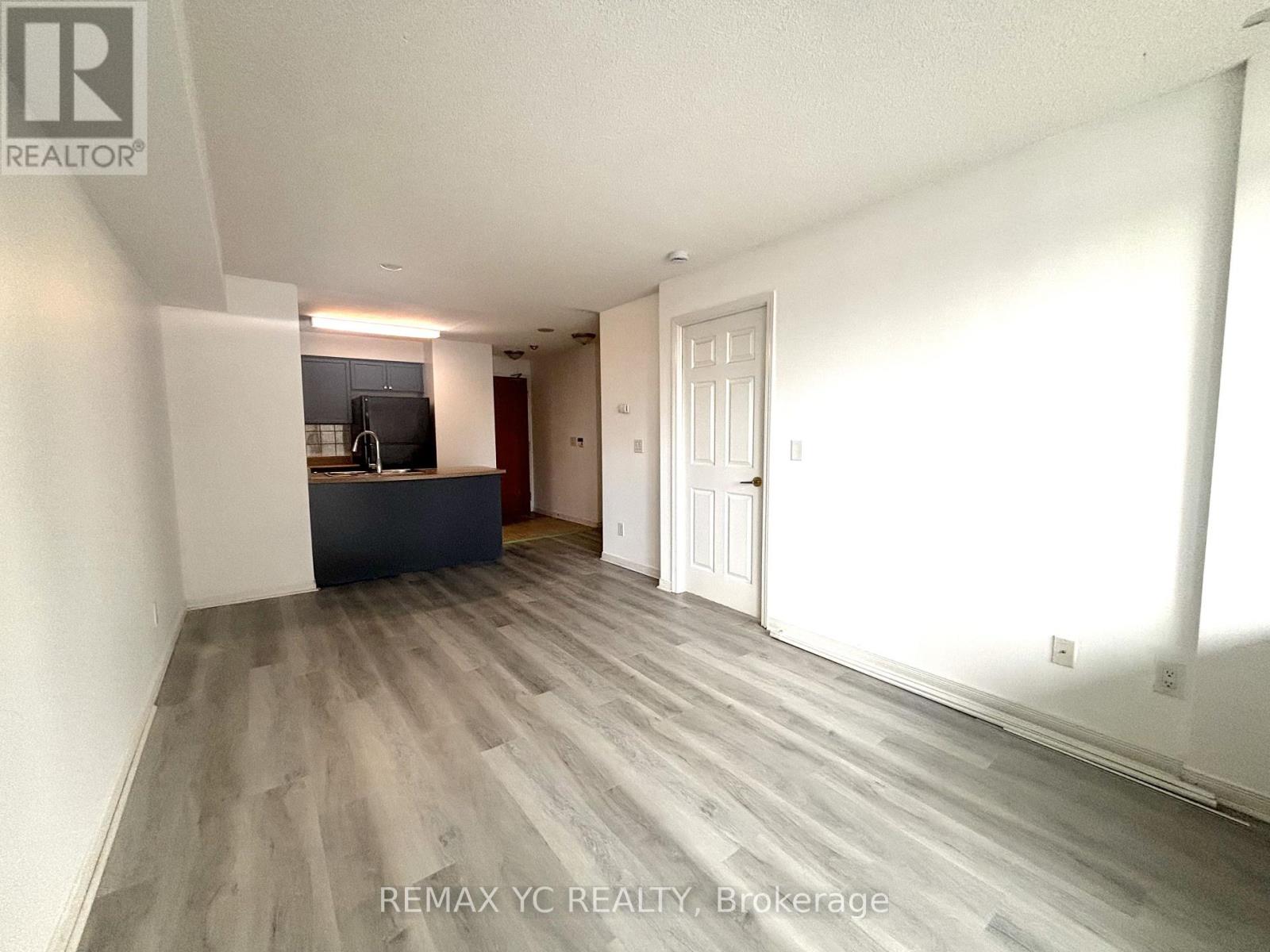 A spacious room with a grey floor and white walls.