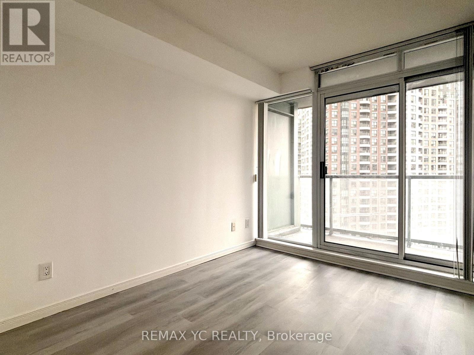 A room with a large window and a view of a building across the street.