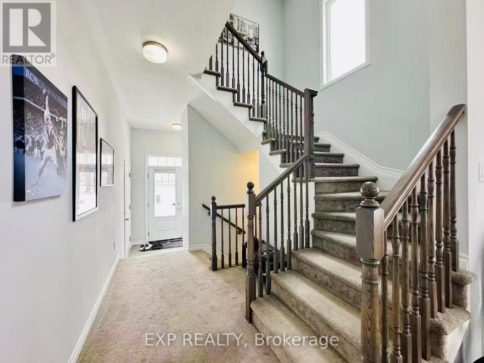 A staircase with a wooden banister and a carpeted floor.