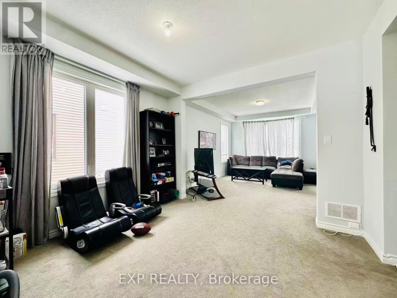 A living room with a black chair, a black bookshelf, and a black sofa.