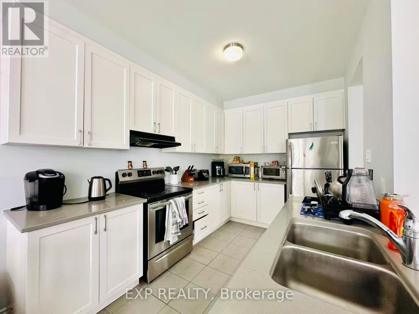 A kitchen with white cabinets and stainless steel appliances.