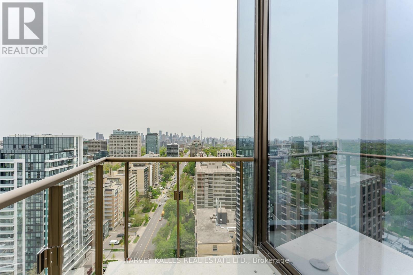 A view from a high-rise apartment looking down a street lined with buildings.
