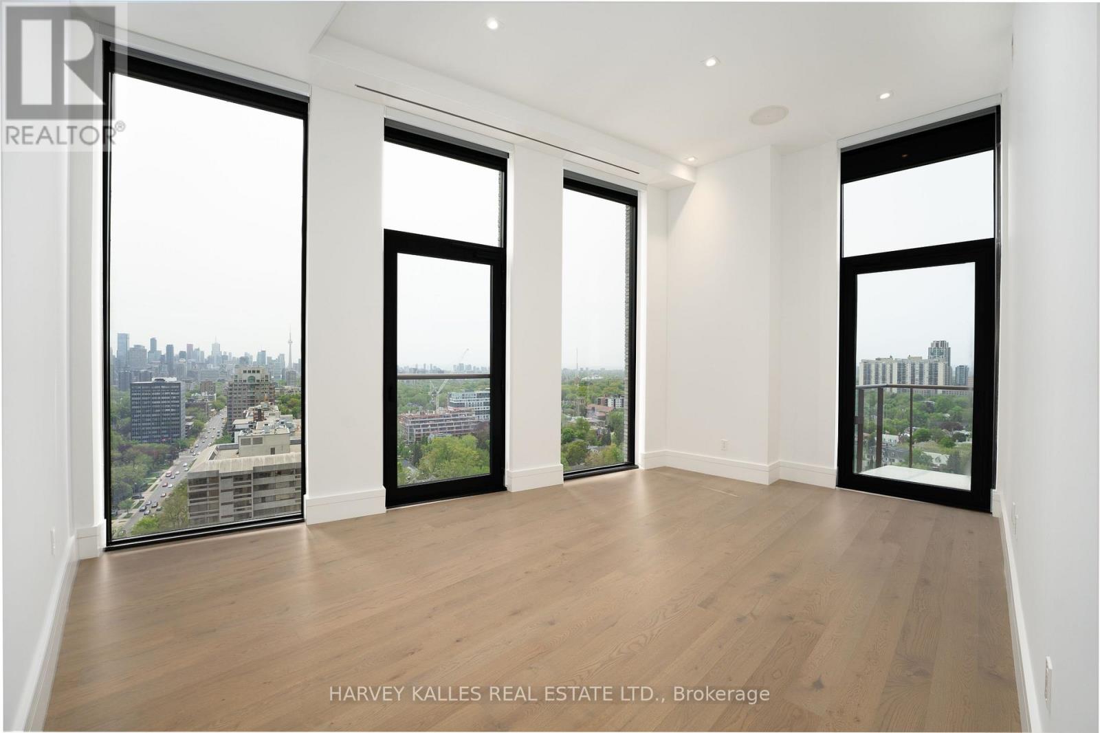 A spacious room with large windows overlooking a cityscape.