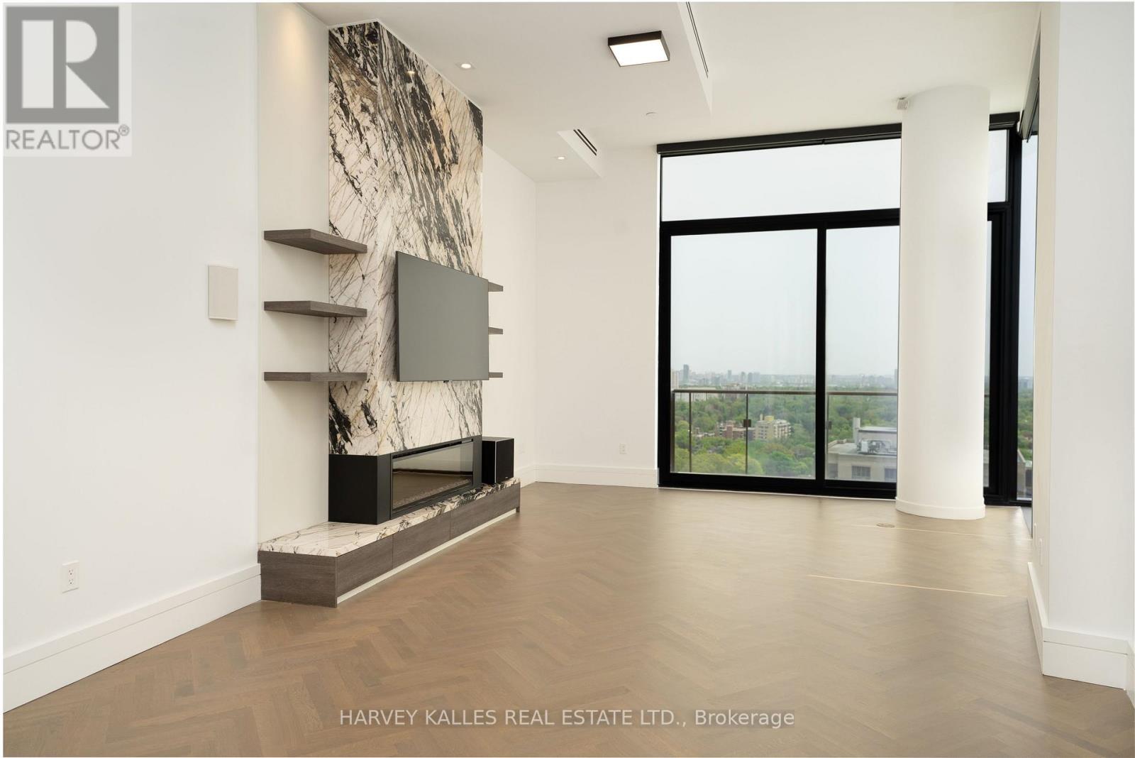 A spacious living room with a fireplace and a view of the city.