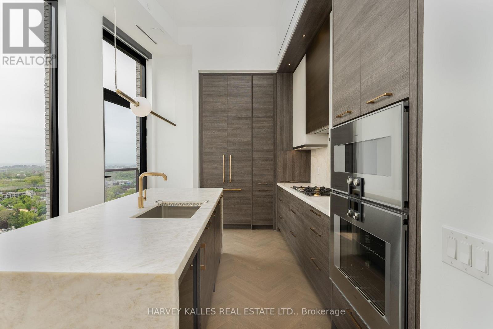 A modern kitchen with a marble countertop and stainless steel appliances.