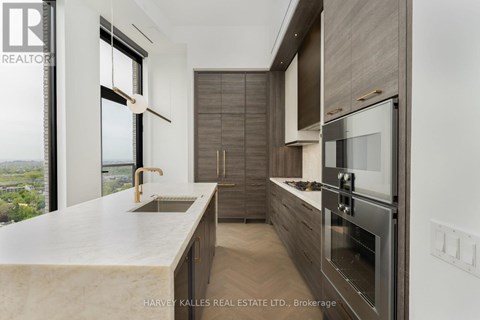 A modern kitchen with a marble countertop and stainless steel appliances.