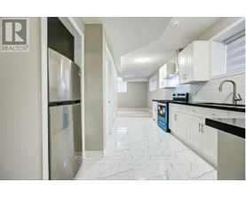 A kitchen with white cabinets and a marble floor.