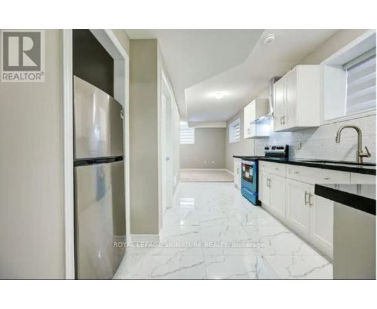 A kitchen with white cabinets and a marble floor.