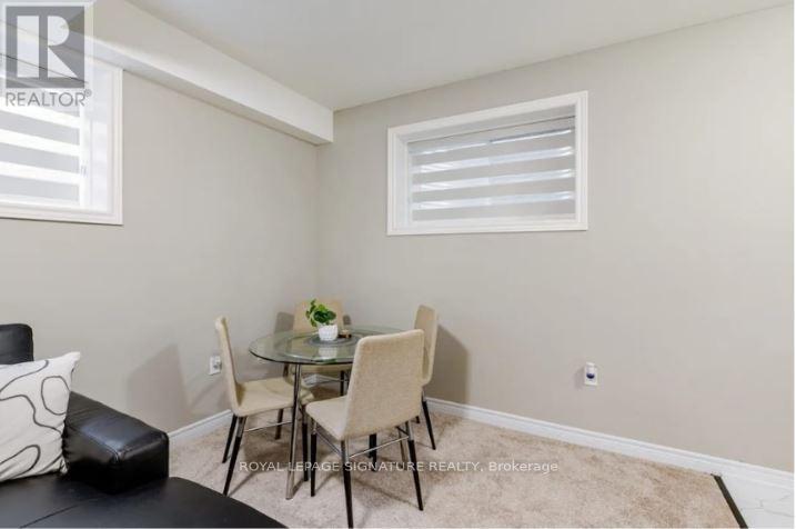 A small dining area with a glass table and four chairs.