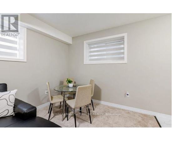 A small dining area with a glass table and four chairs.