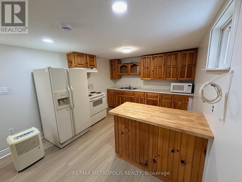 A kitchen with wooden cabinets and a white fridge.