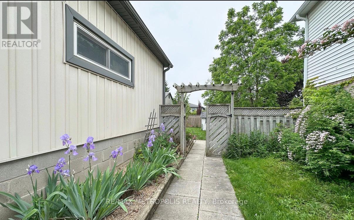 A realtor photo of a house with a grey siding and a white window.