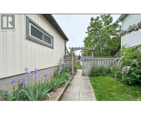 A realtor photo of a house with a grey siding and a white window.