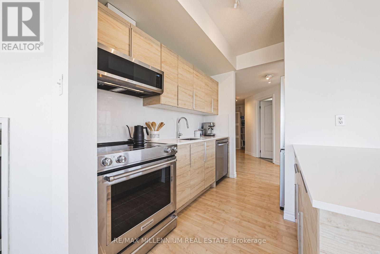 A modern kitchen with wooden cabinets and stainless steel appliances.