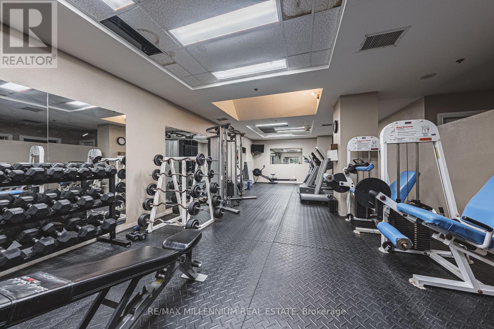 A gym with a variety of equipment including weights and machines.