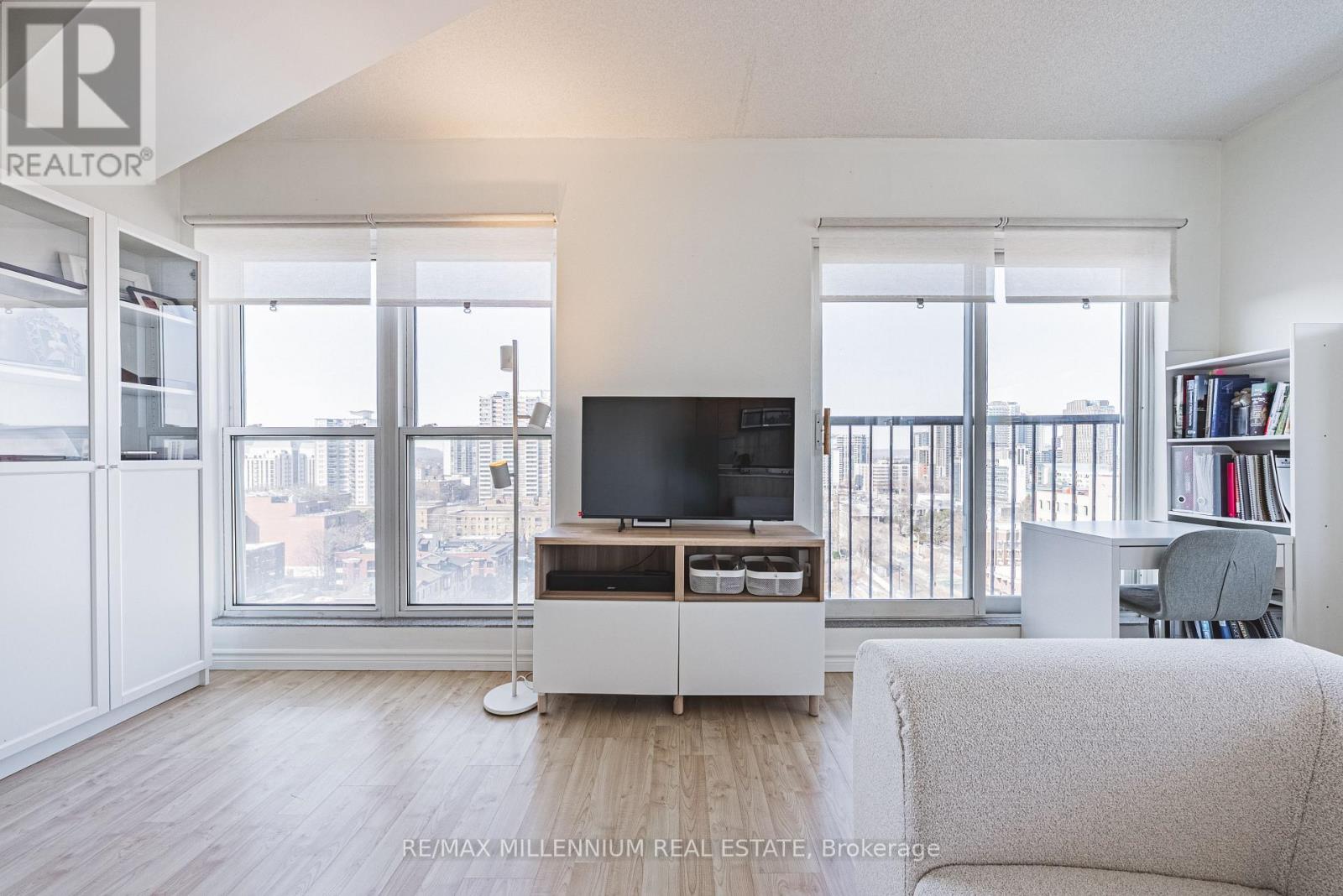 A living room with a television and a large window.