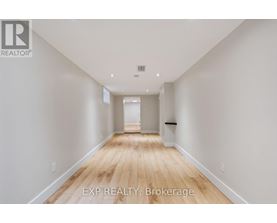 A long, empty hallway with wooden floors and white walls.