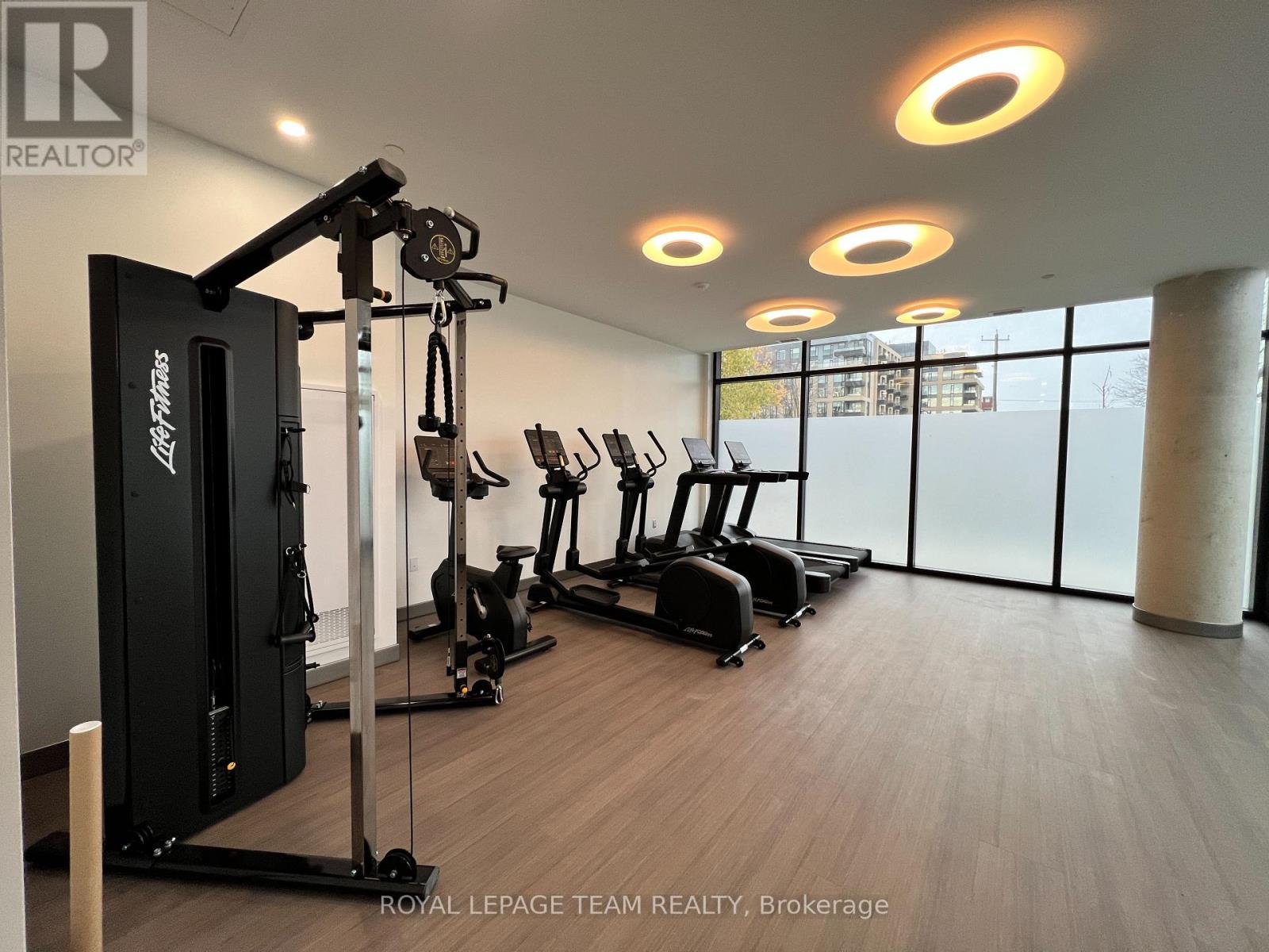 A gym with a row of treadmills and a weight machine.