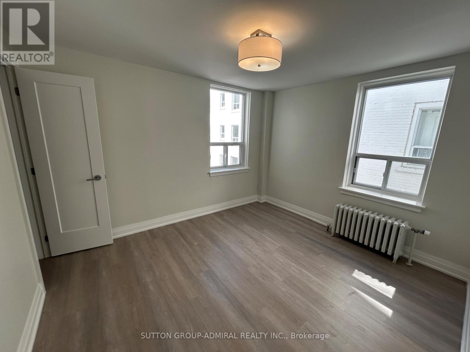 A room with a wooden floor and a white ceiling with a light fixture.