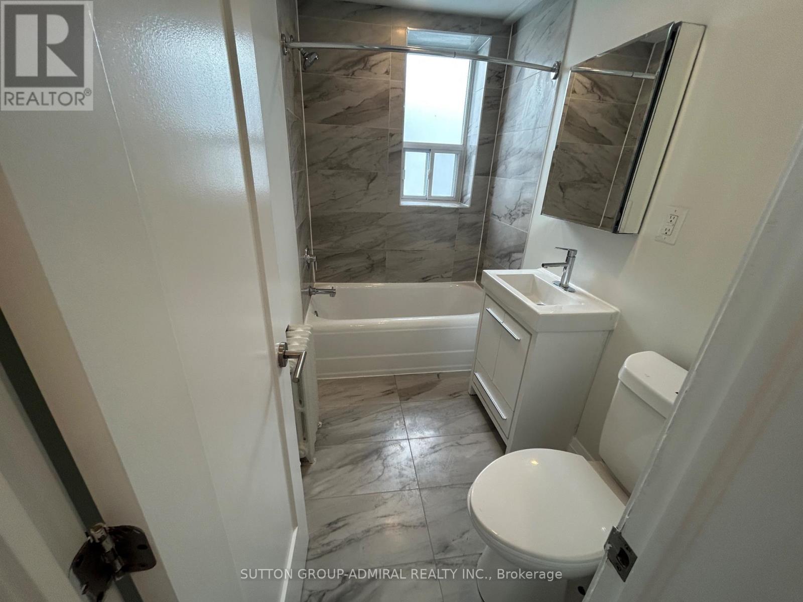 A bathroom with a toilet, sink, and bathtub.