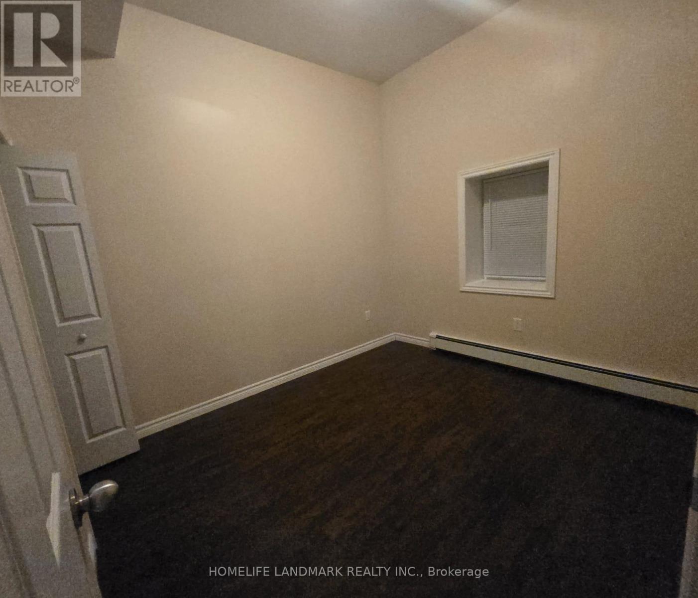 A room with a door, a window, and a wall with a logo.