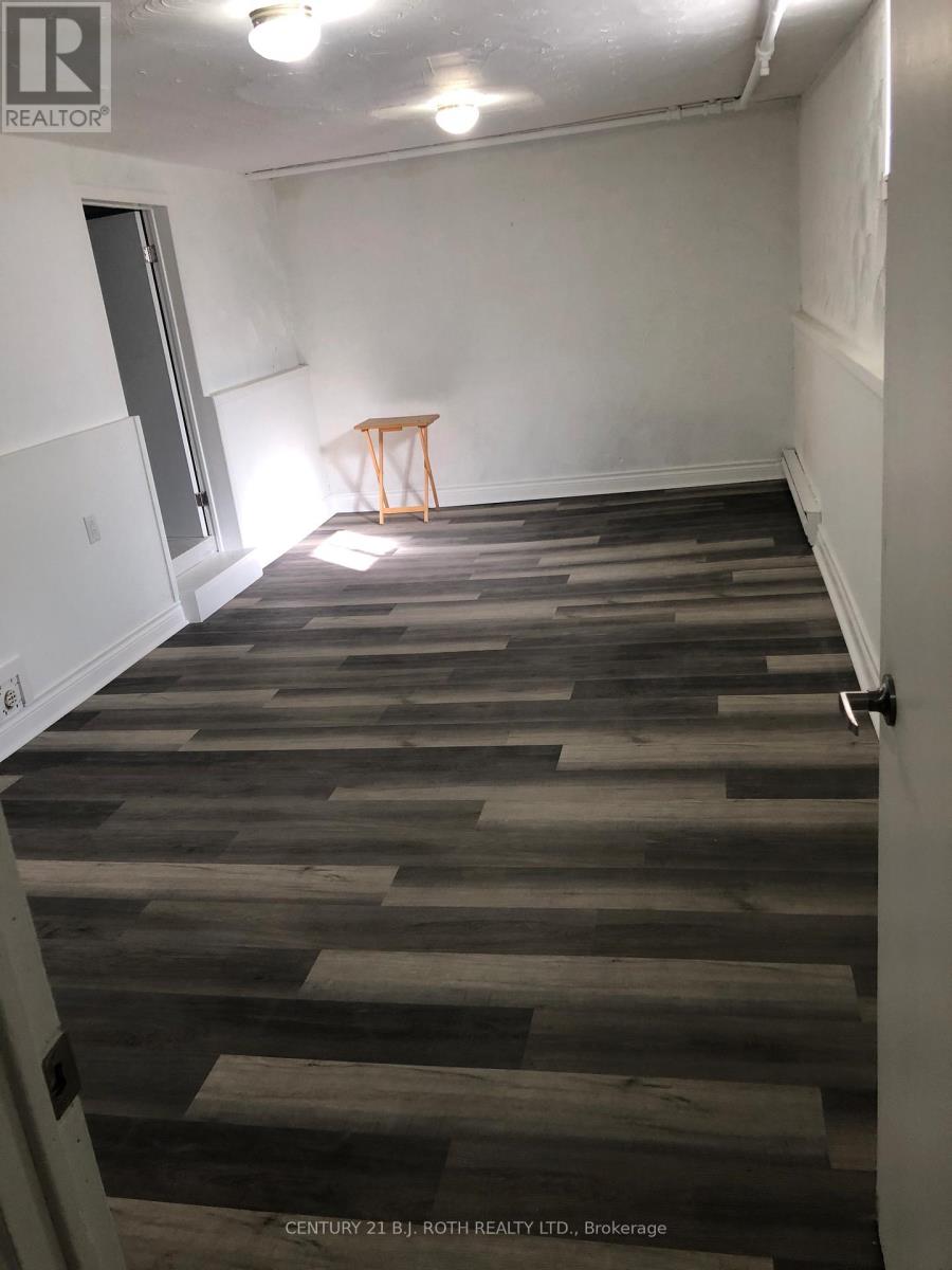 A room with wooden flooring and a small table in the corner.
