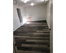 A room with wooden flooring and a small table in the corner.