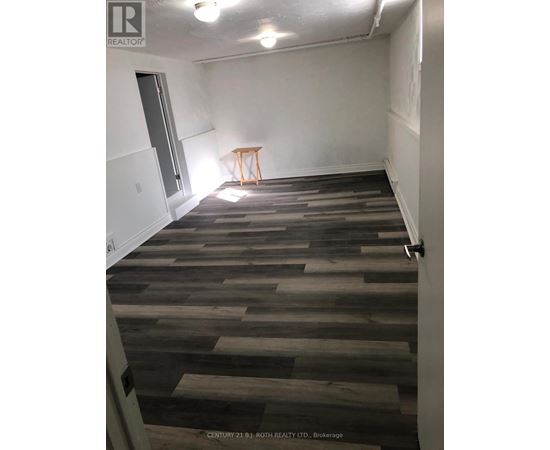 A room with wooden flooring and a small table in the corner.