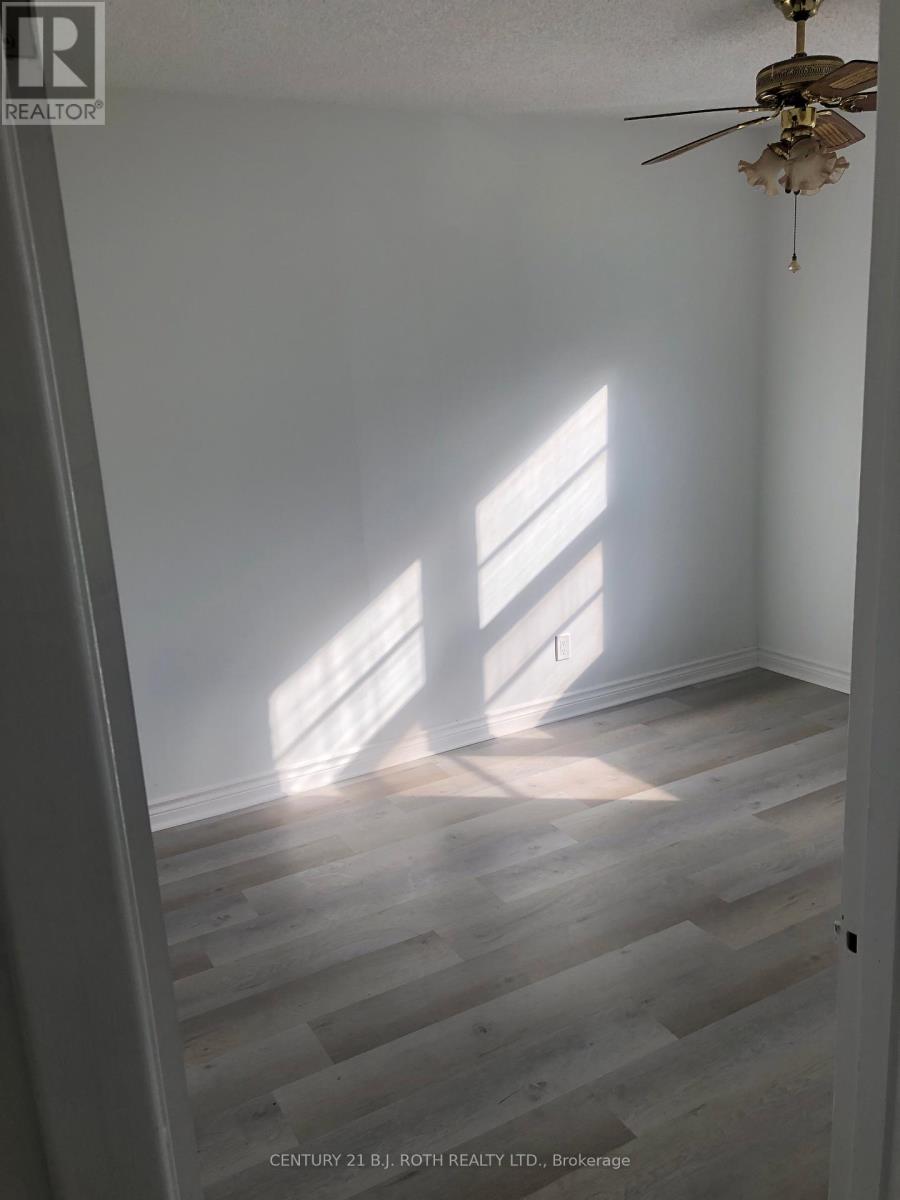 A room with a ceiling fan and light, and a window letting in sunlight.