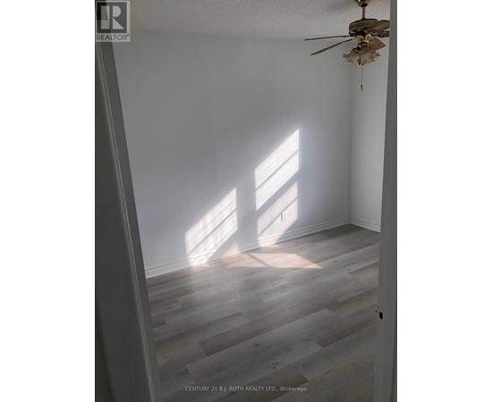 A room with a ceiling fan and light, and a window letting in sunlight.