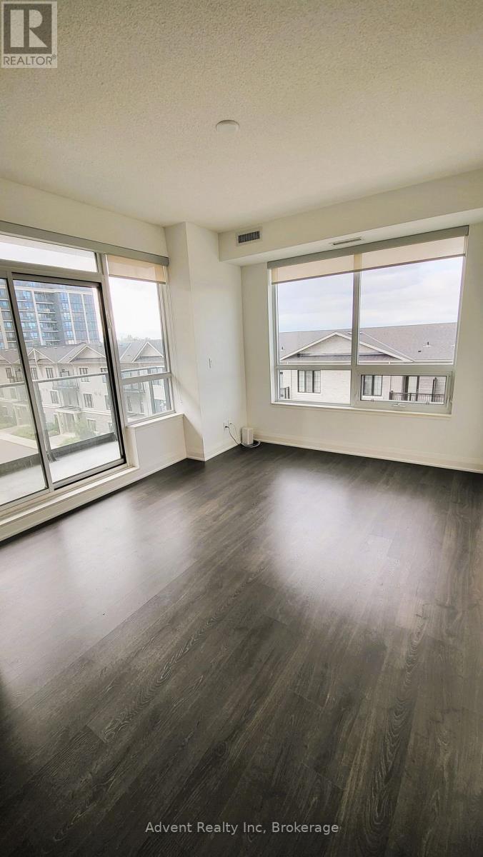 A room with wooden floors and large windows overlooking a cityscape.