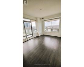 A room with wooden floors and large windows overlooking a cityscape.