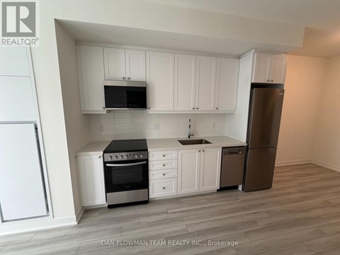 A kitchen with white cabinets and a black stove top oven.