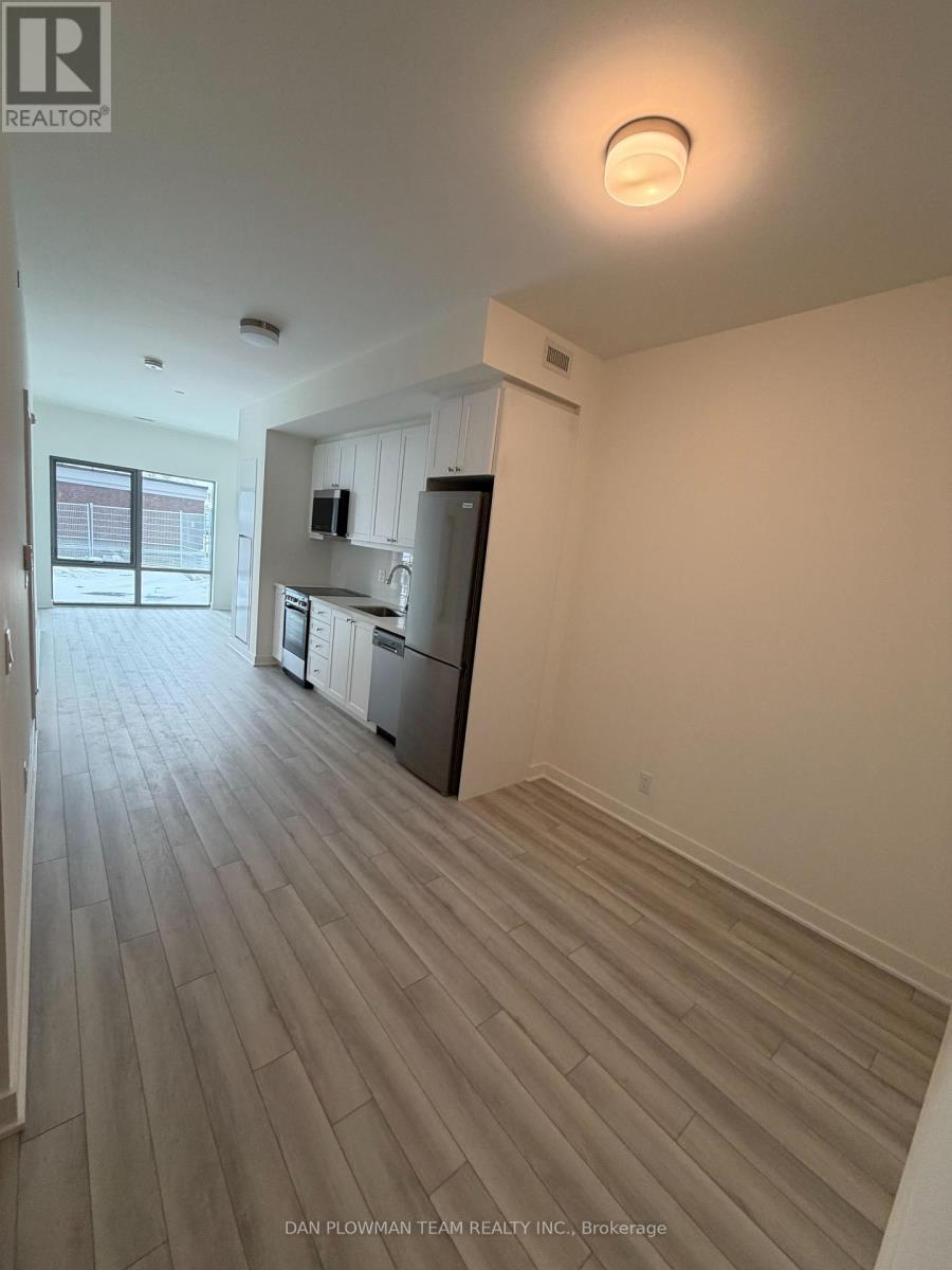 A spacious kitchen with white cabinets and a refrigerator.