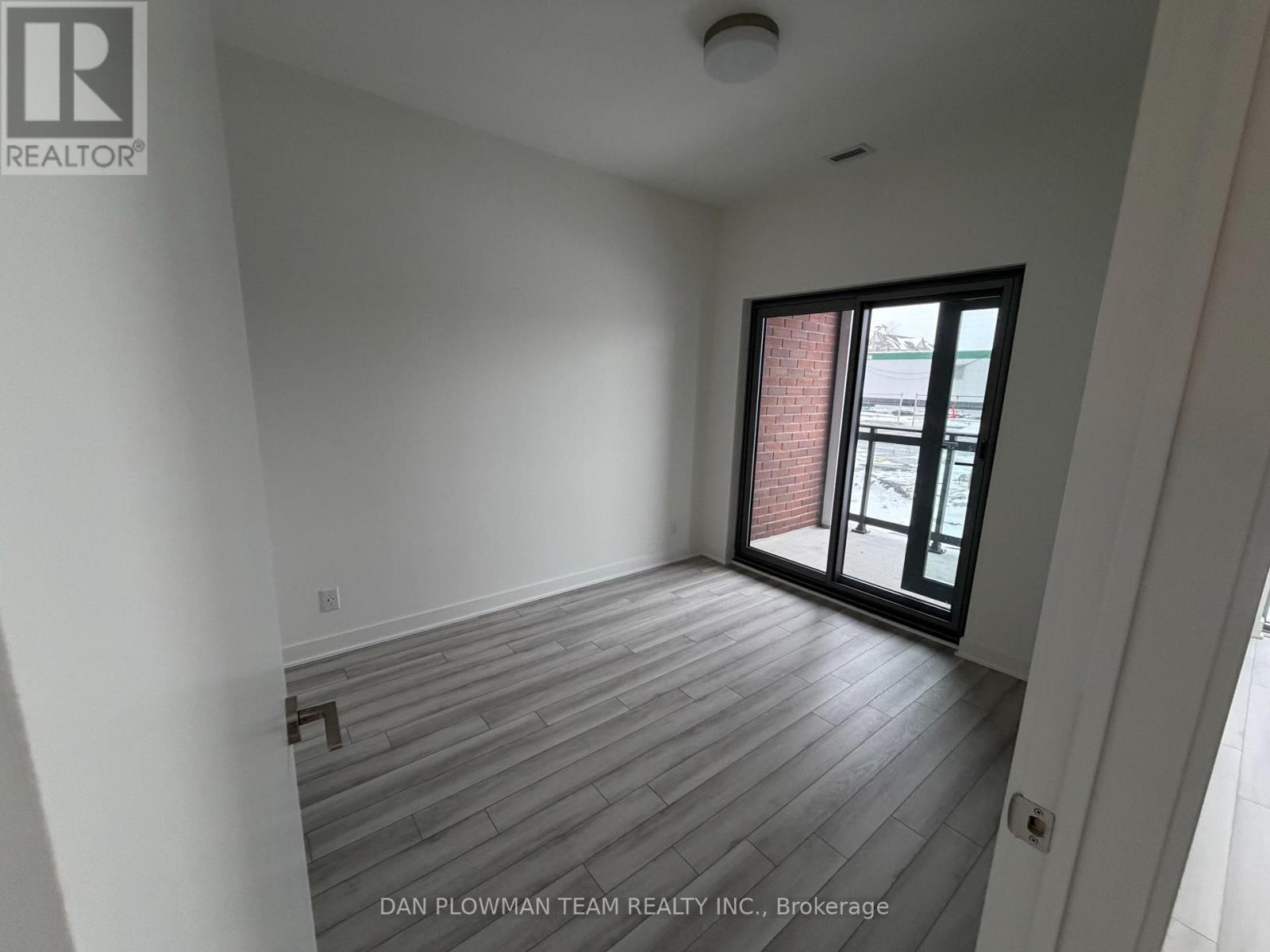 A room with a window and wooden flooring.