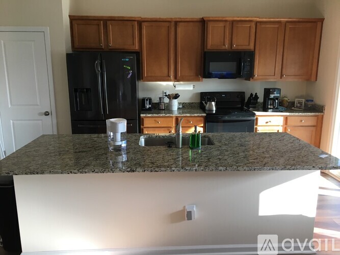A kitchen with granite countertops and wooden cabinets.