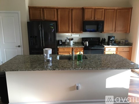 A kitchen with granite countertops and wooden cabinets.