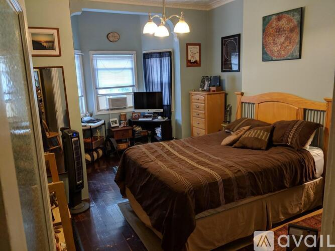 A bedroom with a bed, dresser, and desk.